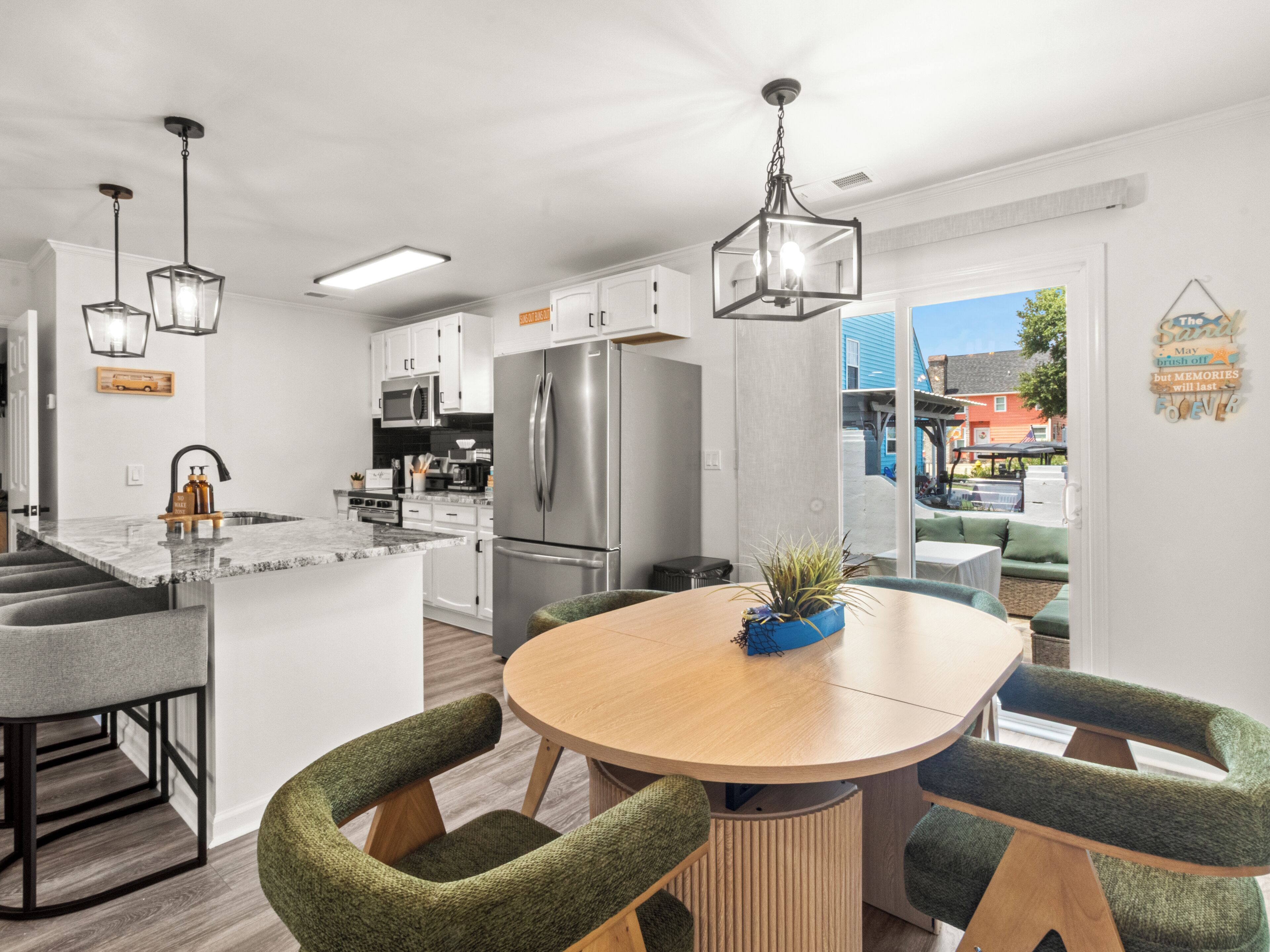 Een moderne keuken met roestvrijstalen apparatuur, een centraal eiland met zitplaatsen en uitzicht op buiten.
