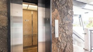 An elevator with a metallic interior and a stone wall adjacent to it. - New Listing, Casa De Emdeko, Ocean views,AC (Kailua Kona)
