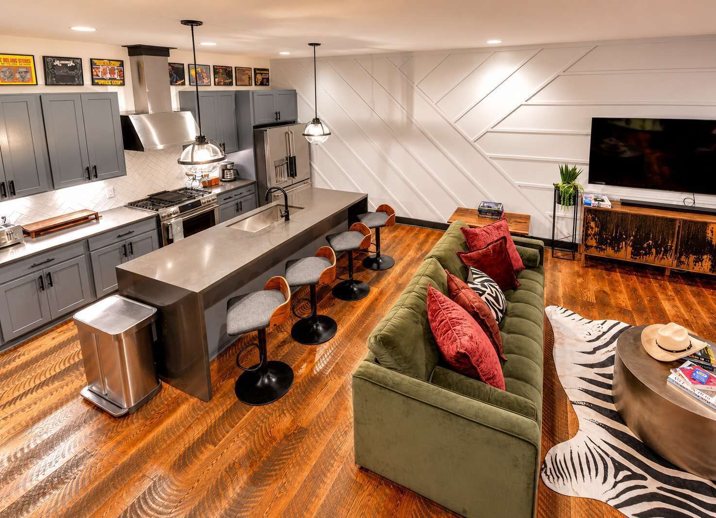 A modern kitchen with a central island, bar stools, and a dining area.