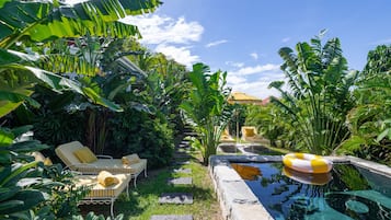 A pool area with lounge chairs and a small pool.