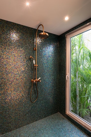 A bathroom with a shower, tiled walls, and a view of greenery outside. - 1493 Boutique Hotel St Barth (St. Barthelemy)