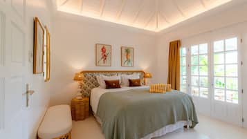 A bedroom with a bed, bedside tables, a window, and a door.