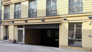 Un edificio con puerta de garaje, ventanas amplias y una puerta con celosía metálica.