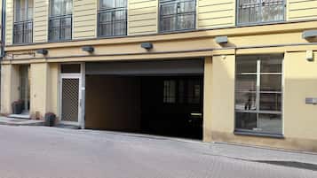 En byggnad med en garageport, stora fönster och en dörr med ett metallgaller.