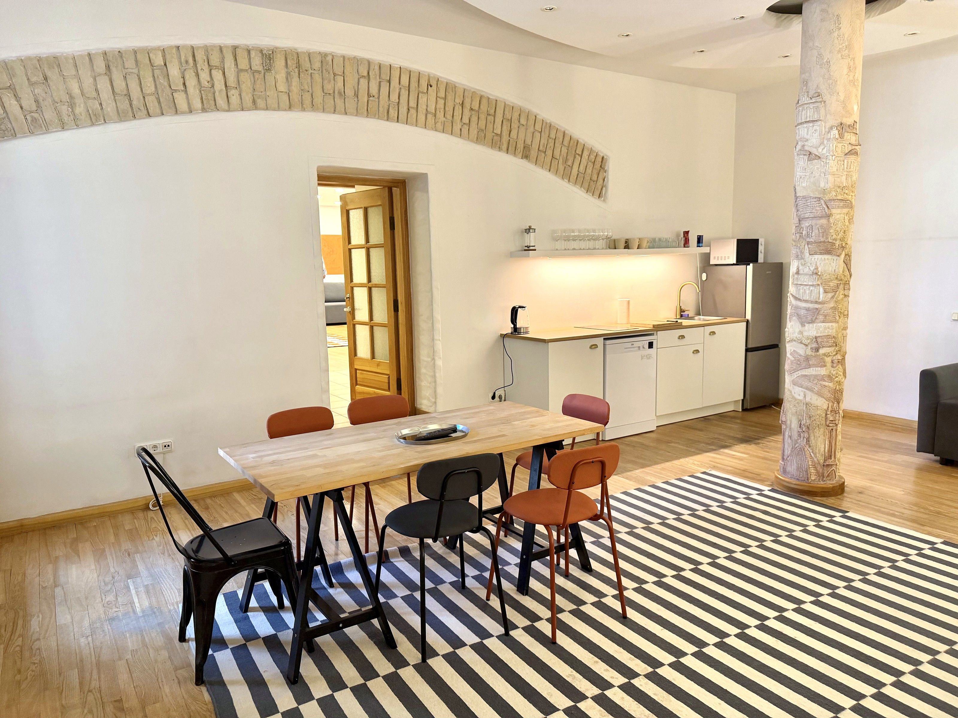 A modern kitchen with white cabinets, a wooden countertop, and a built-in dishwasher.