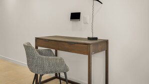 A modern desk with a chair, a wall-mounted light, and a power outlet. - Designer Green Point Stay | Pool and Balcony (Cape Town)