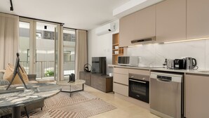 A modern kitchen with a built-in oven, microwave, and dishwasher. - Designer Green Point Stay | Pool and Balcony (Cape Town)