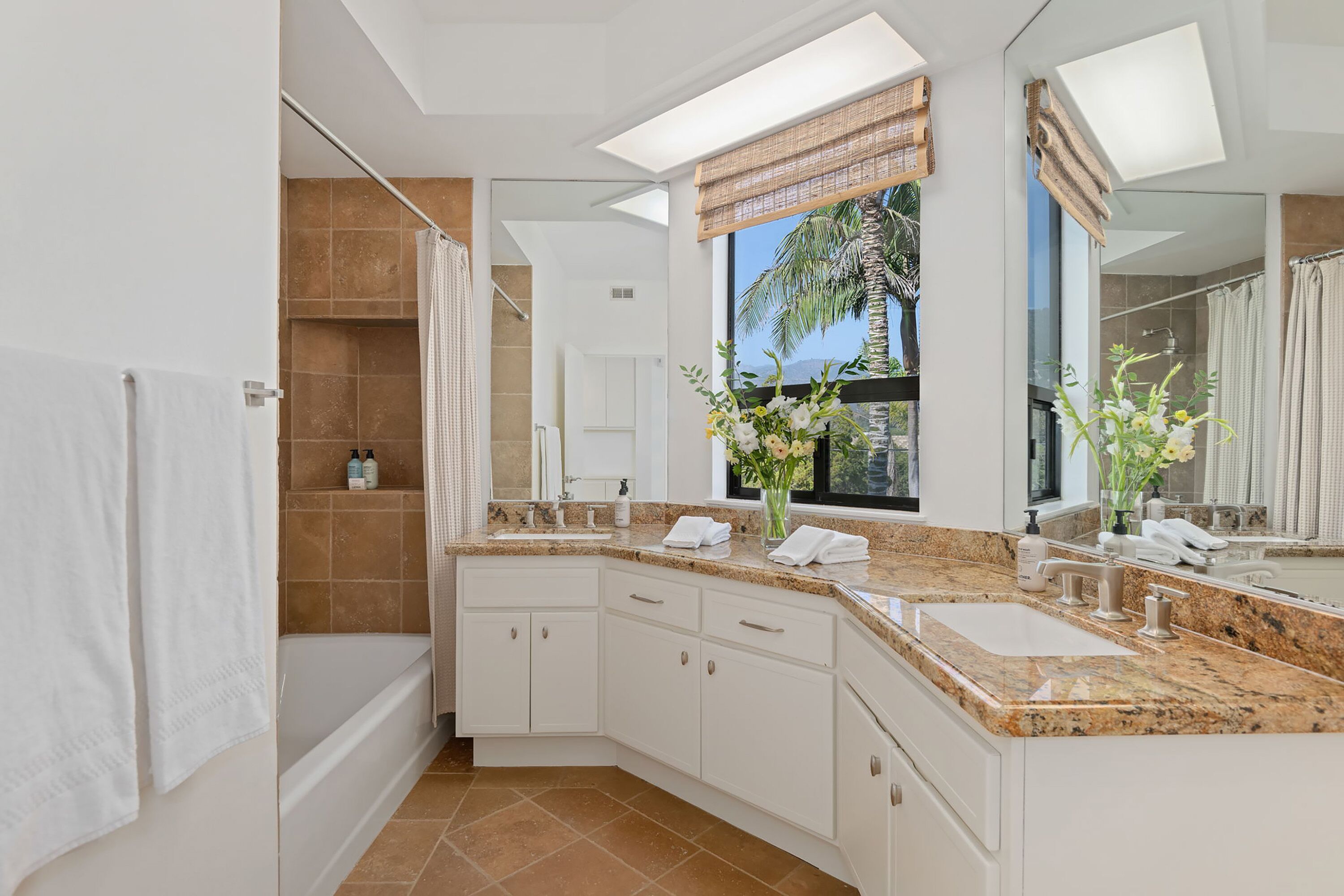 A modern bathroom with a double sink vanity, a shower area, and a large mirror.