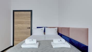 Ein Hotelzimmer mit einem Bett, zwei Kissen, einem Kopfteil und einer Tür.