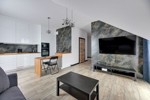 A modern kitchen with white cabinets, a wooden countertop, and a built-in oven. - Botanica Jelitkowo Morze i Slow (Gdańsk)