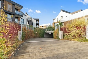 A modern residential area with a paved driveway leading to a covered entrance. - Botanica Jelitkowo Morze i Slow (Gdańsk)