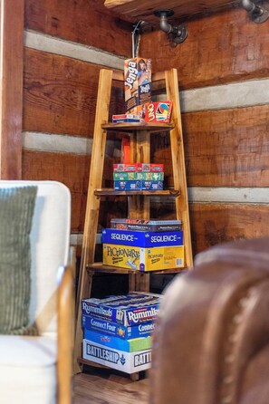Un estante de madera con varios juegos de mesa y rompecabezas.
