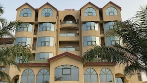 Un hotel de varios pisos con fachada simétrica, ventanas amplias y una entrada central.
