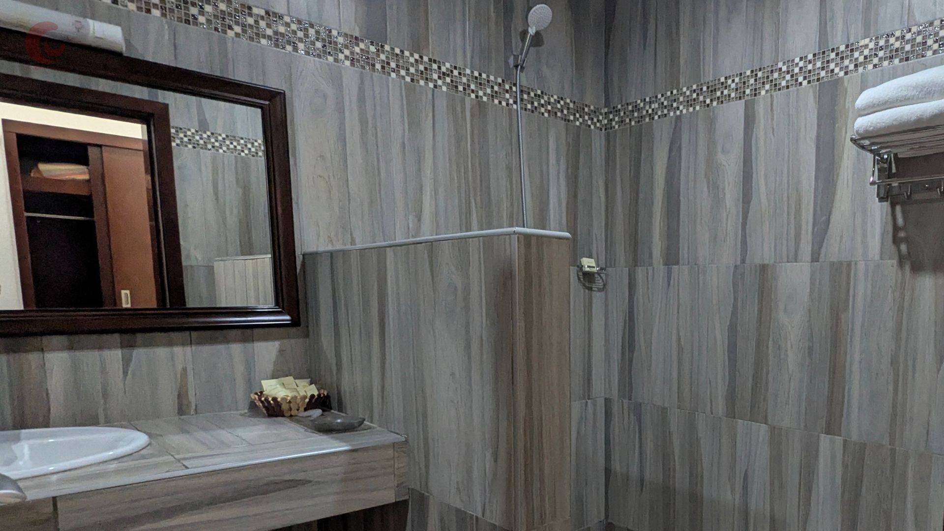 Une salle de bain moderne avec une douche, un lavabo et un miroir.