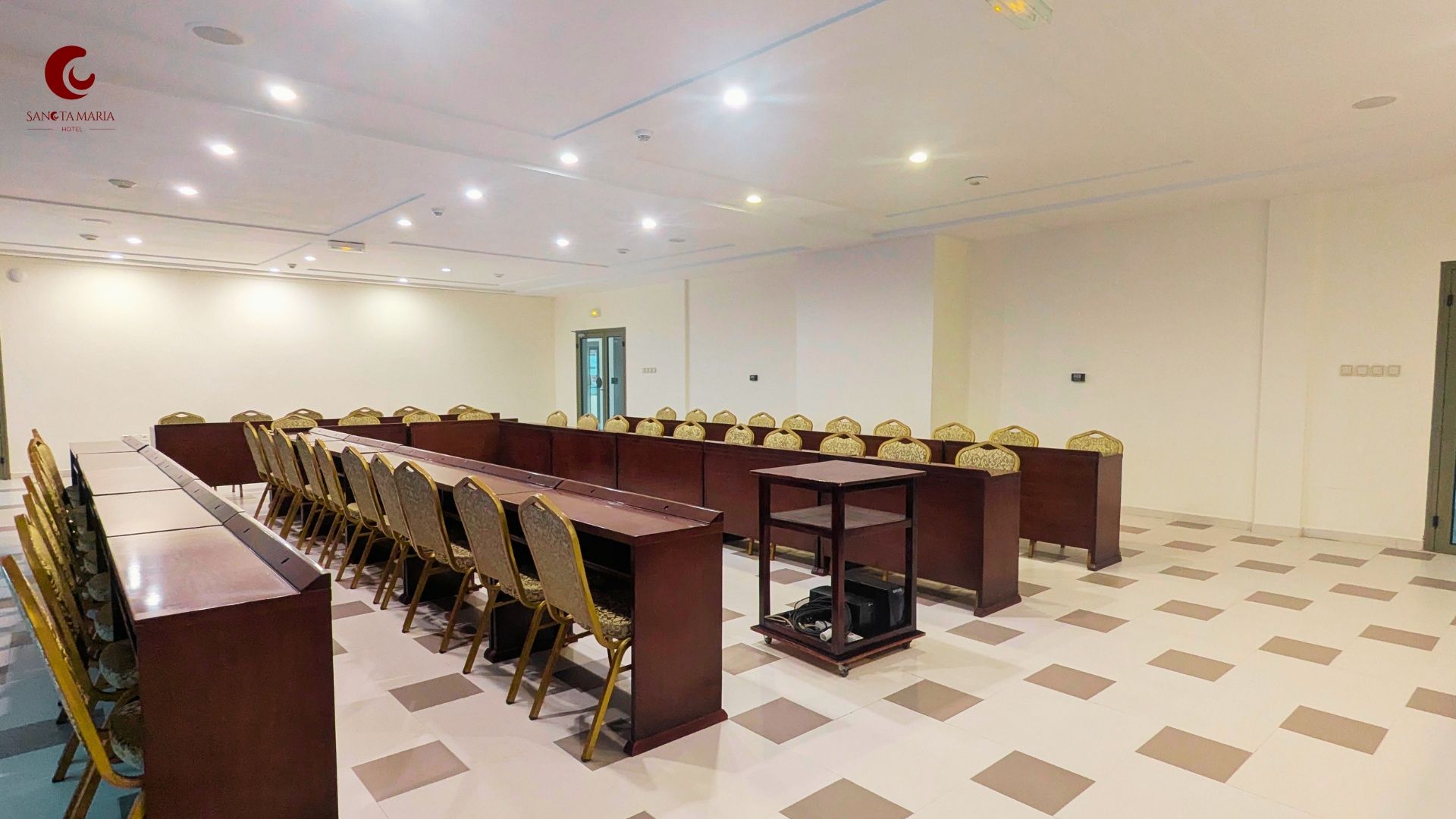 A conference room with a long table and chairs, a projector, and a door in the background.