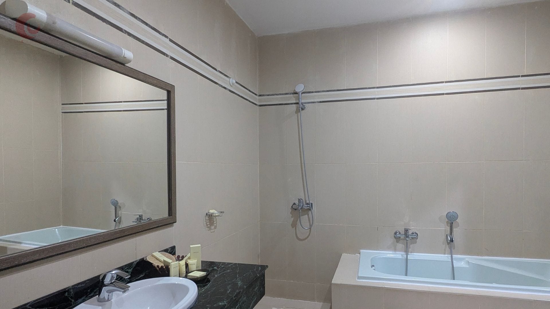 A bathroom with a bathtub, a shower, a sink, and a mirror.