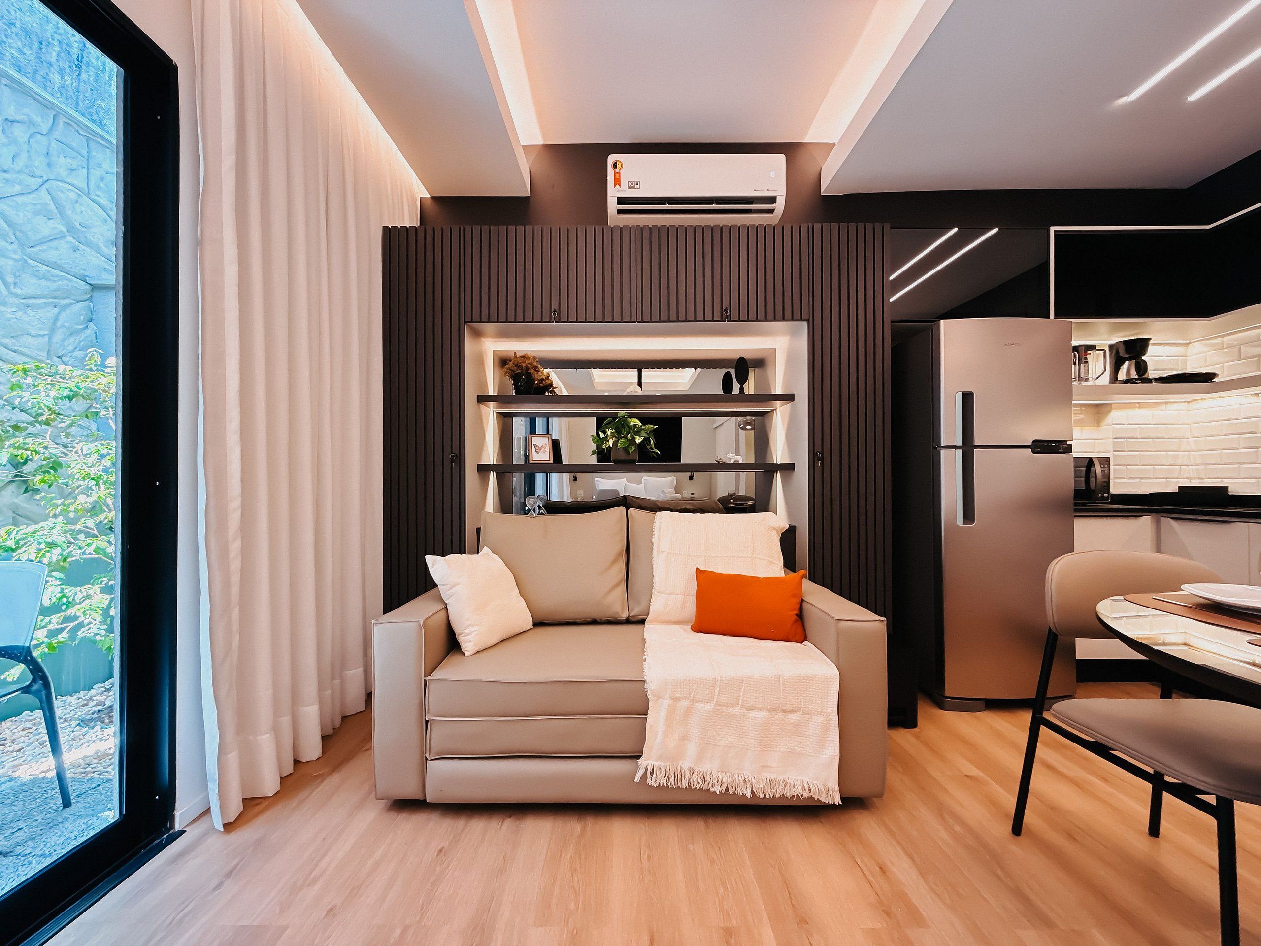 Una sala moderna con sofá, una mesa de centro y un comedor con una silla y una mesa.