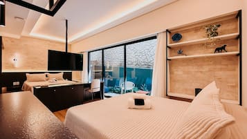 Een moderne hotelkamer met een groot bed, een bureau, een flatscreen-televisie en uitzicht op de omgeving.