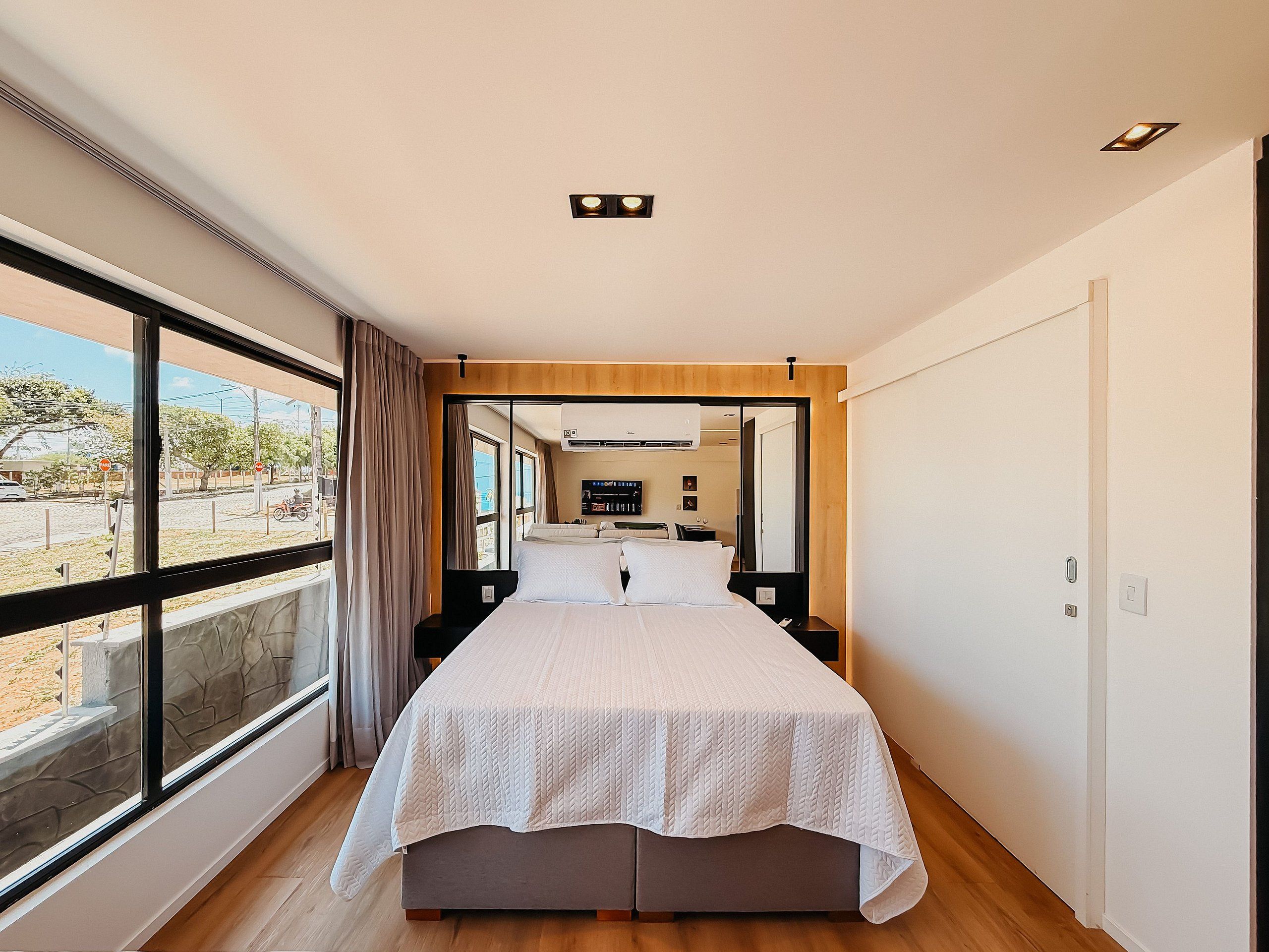 Une chambre d’hôtel avec un grand lit, une télévision et une vue par la fenêtre.