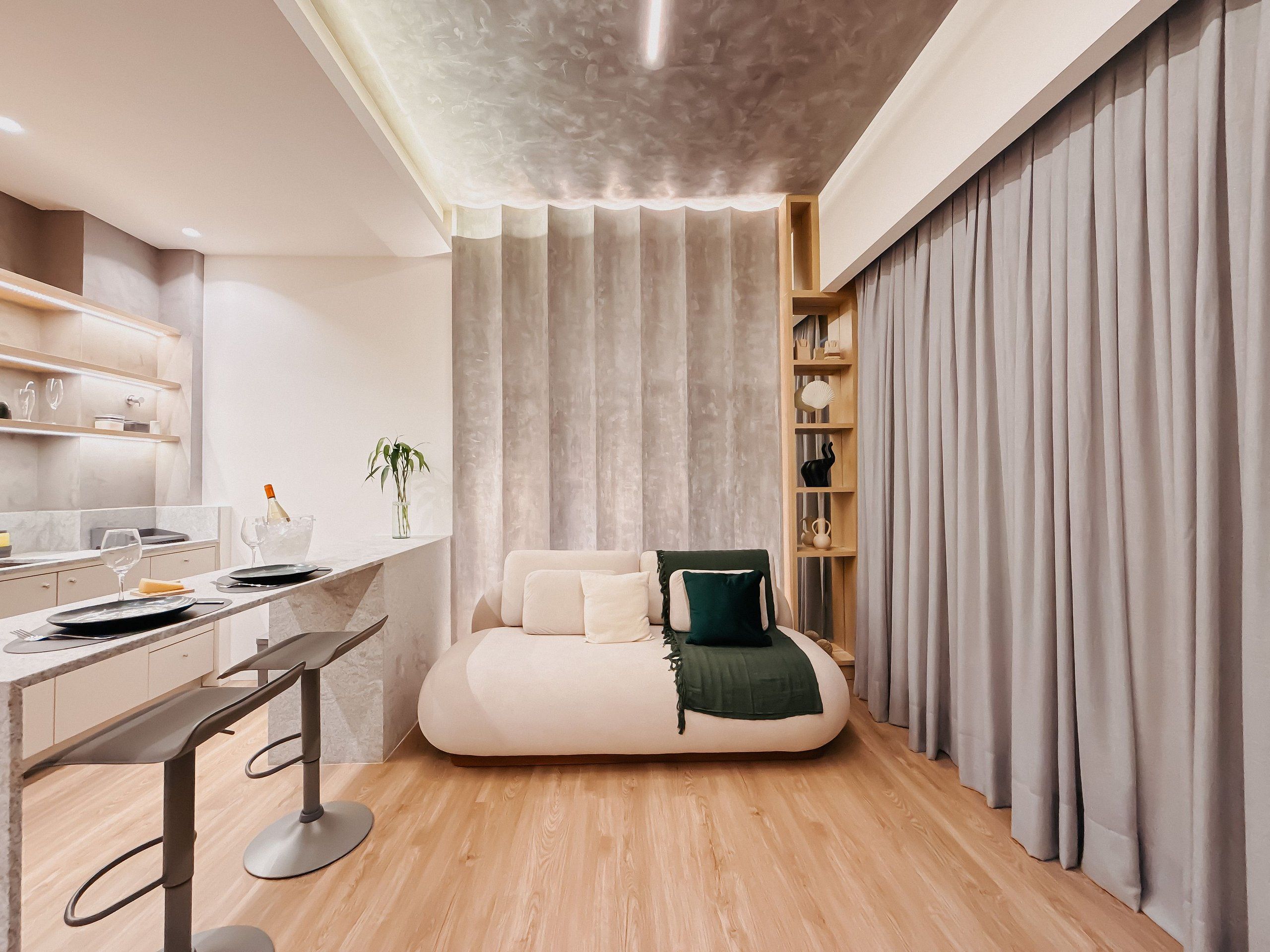 A modern room with a bed, a desk, and a shelving unit.