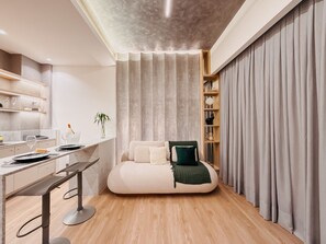 Una habitación moderna con cama, escritorio y estantería.