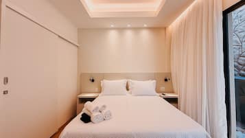 A modern hotel room with a large bed, a nightstand, and a window with curtains.
