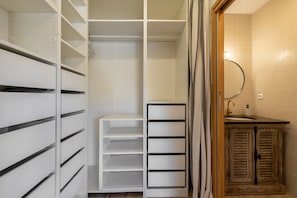 Ein begehbarer Kleiderschrank mit offenen Regalen und einem Holzschrank.