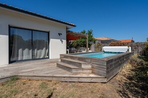 A modern house with a wooden deck, a swimming pool, and a covered patio area. - Les Hirondelles du Lac - Avec piscine privée (La Teste-de-Buch)