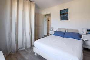 Ein Schlafzimmer mit einem Bett, einem Nachttisch, einer Lampe und einem Bild an der Wand.