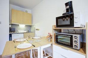 A compact kitchen with a microwave, toaster, and a small refrigerator. - L’Écrin de Bolquère - Studio proche de la station (Bolquère)