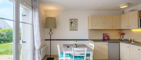 Una cocina compacta con comedor, una lámpara y vista al exterior.
