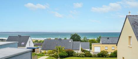 Un quartier résidentiel avec des maisons, une pelouse verdoyante et une vue sur la mer.