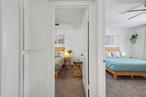 A bedroom with a bed, bedside table, lamp, and a hanging plant. - Quiet 2BR Retreat Fast Wi-Fi Near Dining & Shops (Bakersfield)