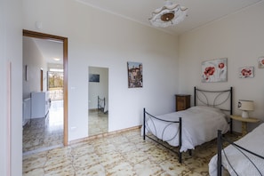 A bedroom with a bed, a bedside table, a lamp, and a painting on the wall. - Villa Etna Pool & Seaview by Wonderful Italy (Belpasso)