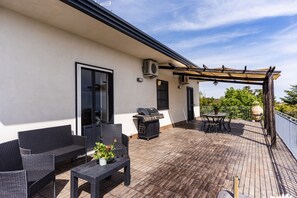 A covered outdoor patio with wicker furniture, a grill, and a pergola. - Villa Etna Pool & Seaview by Wonderful Italy (Belpasso)