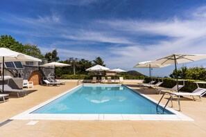 A swimming pool with sun loungers and umbrellas, surrounded by greenery and a clear sky. - Villa Etna Pool & Seaview by Wonderful Italy (Belpasso)