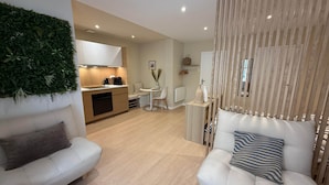 A modern living room with a sofa, a coffee table, and a decorative wall. - La Bohème - Historic City Centre Studio – Aix Cours Mirabeau (Aix-en-Provence)