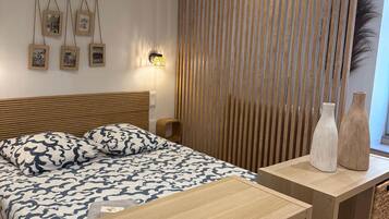 Een slaapkamer met een bed, nachtkastjes, een wandlamp en een decoratief wandpaneel.