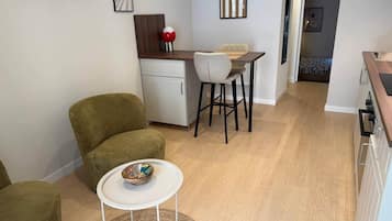 A compact living space with a kitchenette, a dining area, and a seating area with a small table and chairs.