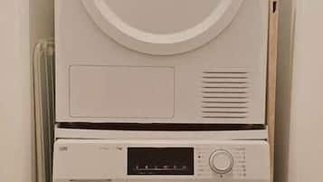 A compact, wall-mounted washer and dryer unit in a narrow hallway.