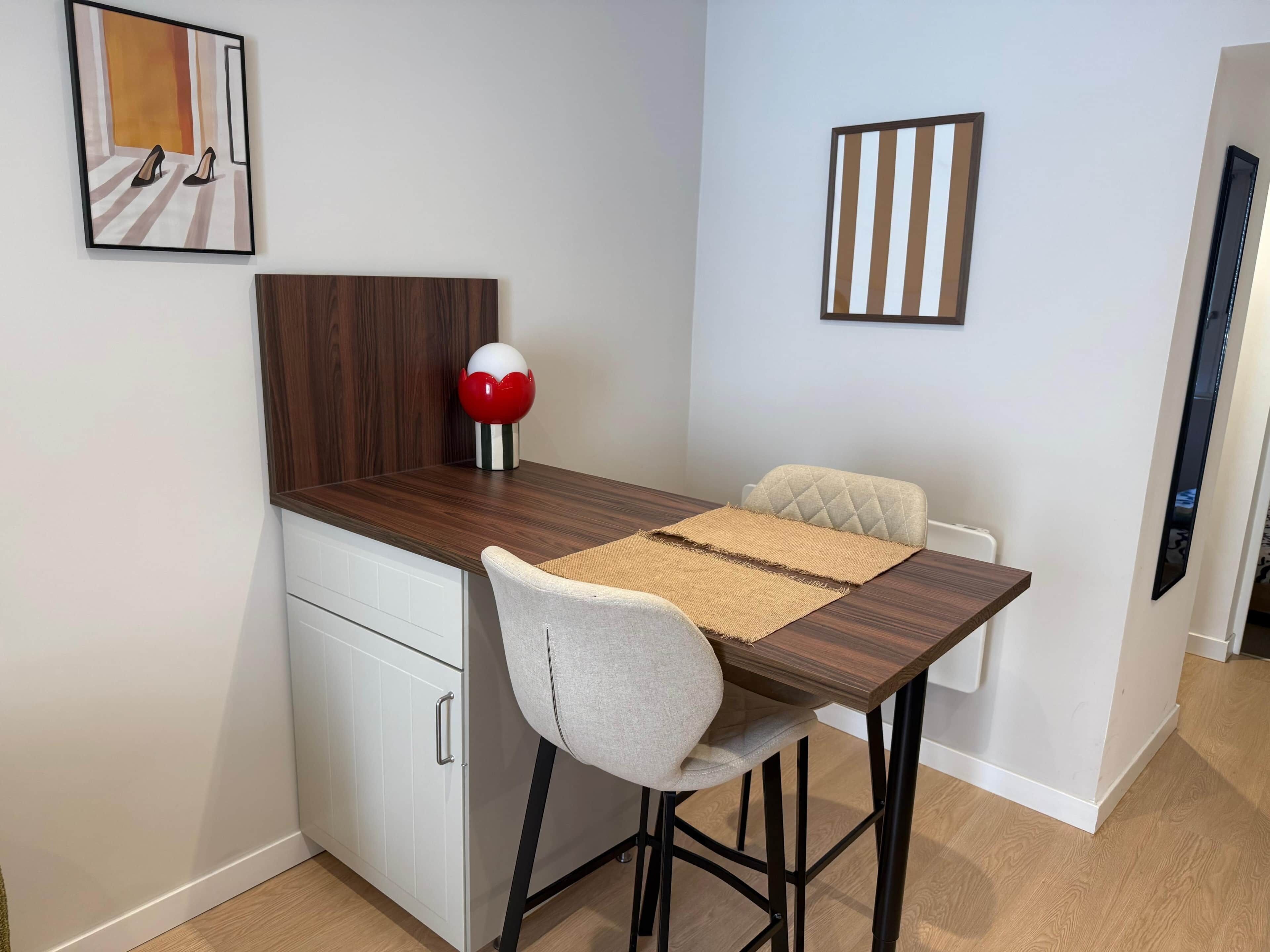 A compact dining area with a wooden table, a single chair, and a small decorative item on the table.