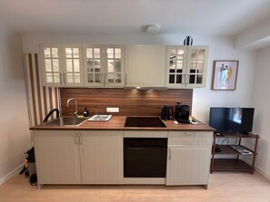 Eine moderne Küche mit eingebautem Geschirrspüler, Herd und Kaffeemaschine.