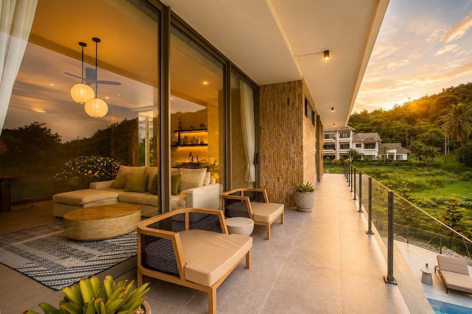 Un espacio exterior moderno con pared de vidrio, zona de estar y vista a un edificio residencial.