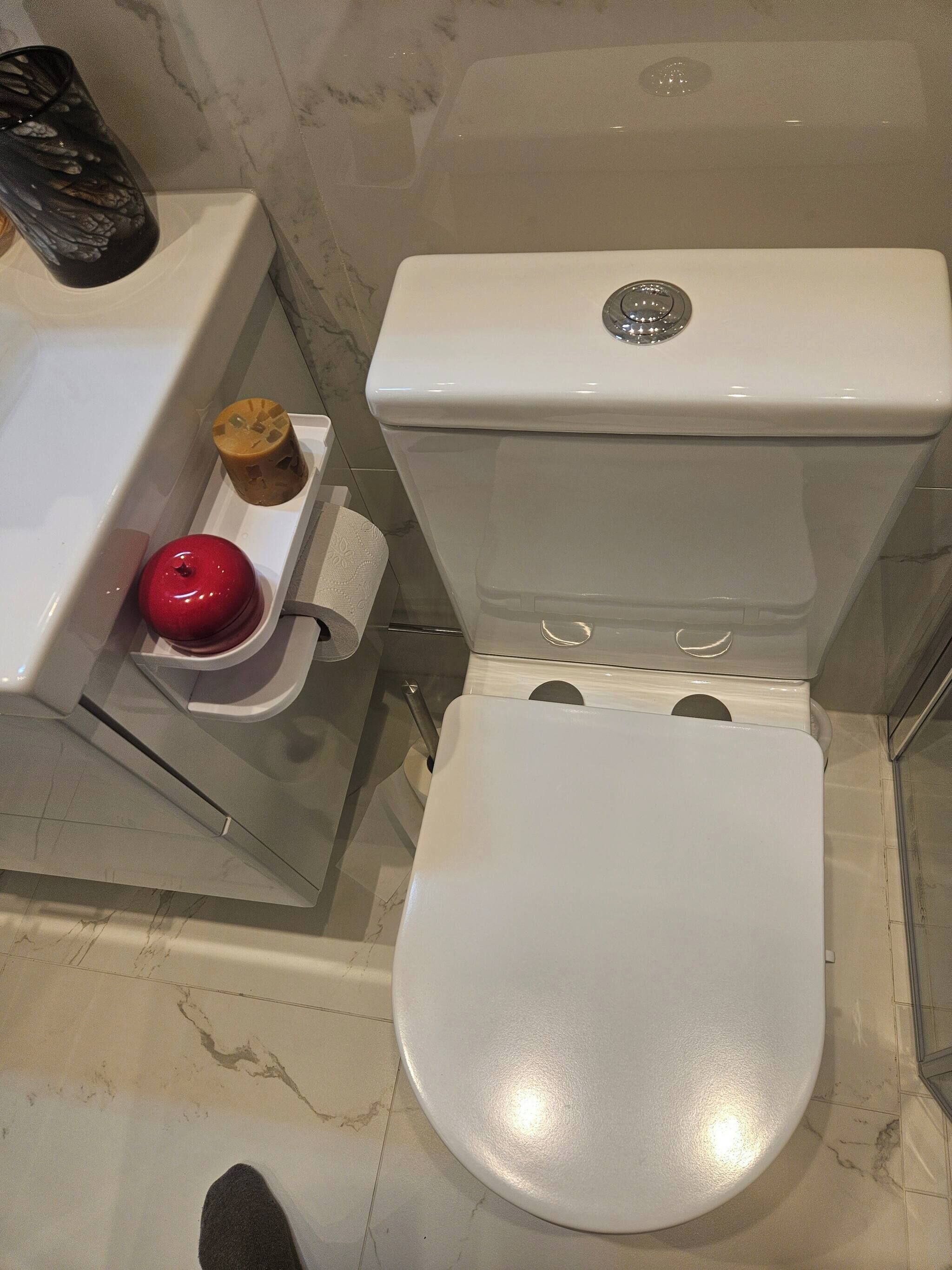 A bathroom with a toilet, a bidet, and a trash bin.