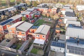 Zona residencial con varias casas, algunas con paneles solares, y un parque infantil.