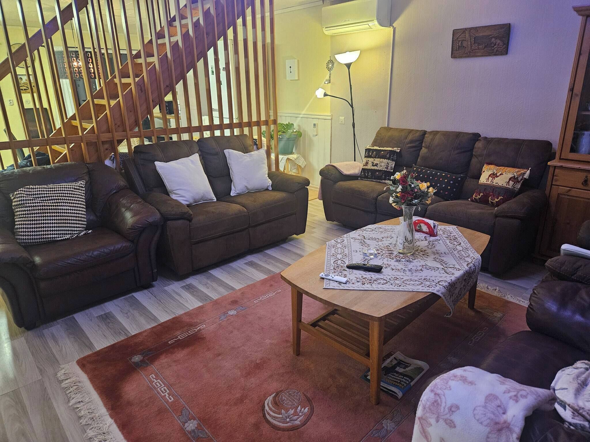 A living room with two sofas, a coffee table, and a staircase.