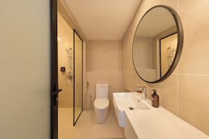 A modern bathroom with a toilet, bidet, and a sink with a mirror. - Asai Gamuda Cove (Banting)