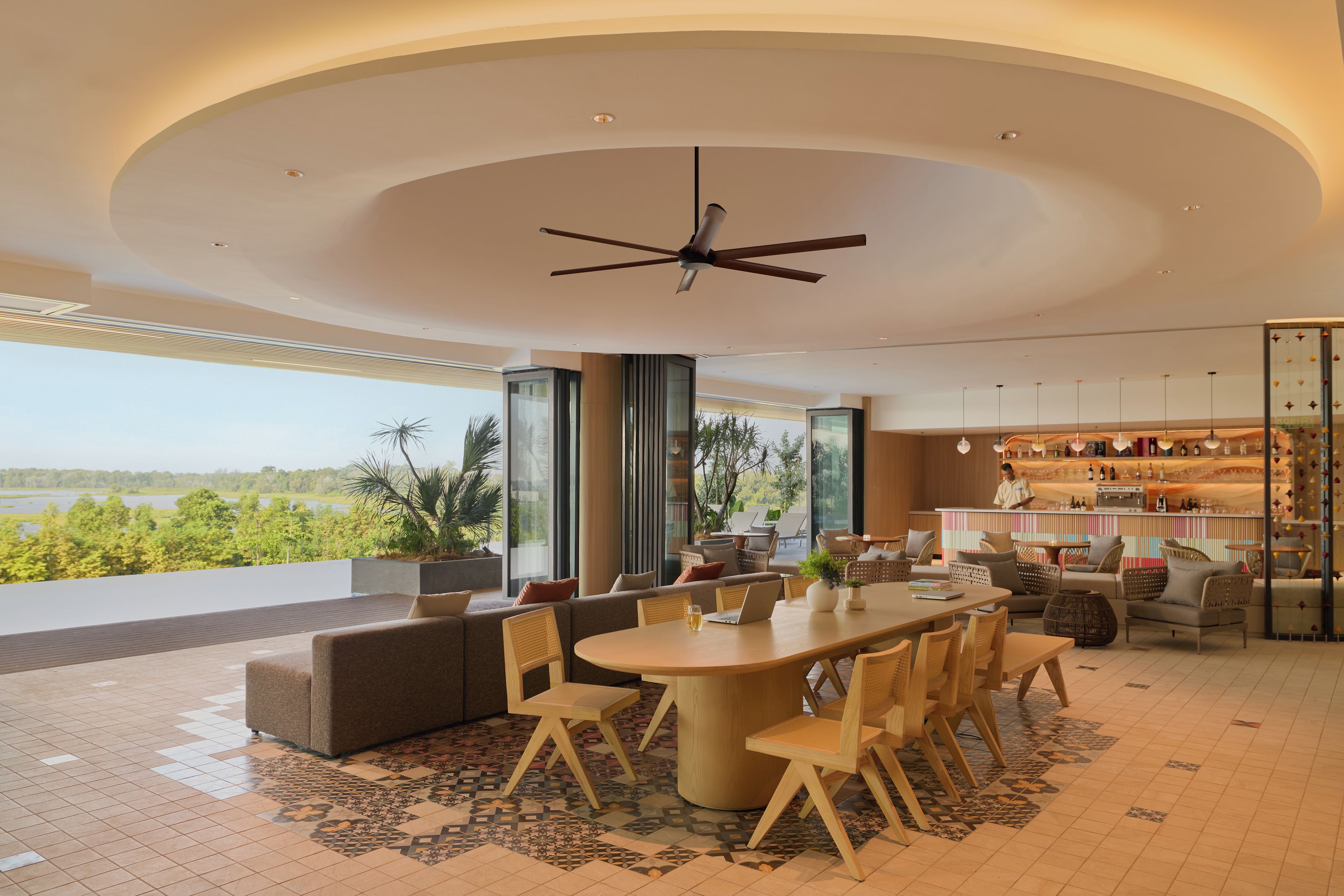 A modern interior with a dining area, sofas, and a bar.