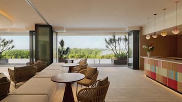 A modern outdoor seating area with wicker furniture, a round table, and a bar with a colorful design.