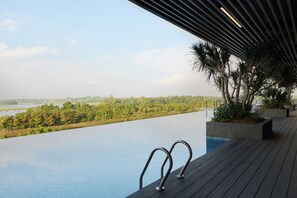 An infinity pool with a view of a lake and forest. - Asai Gamuda Cove (Banting)